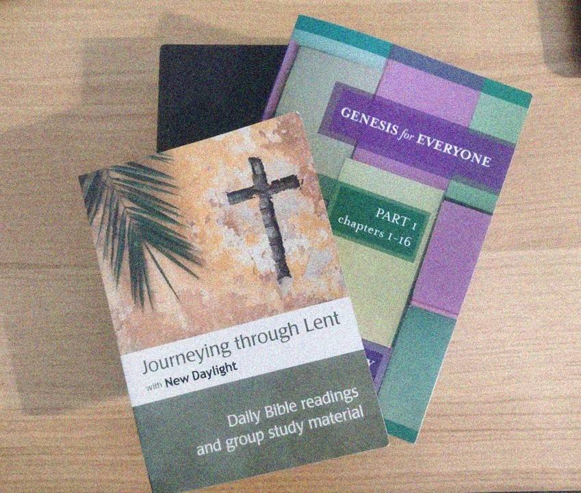 Three books in a pile which are the bible, a journey through lent, and Genesis for everyone.