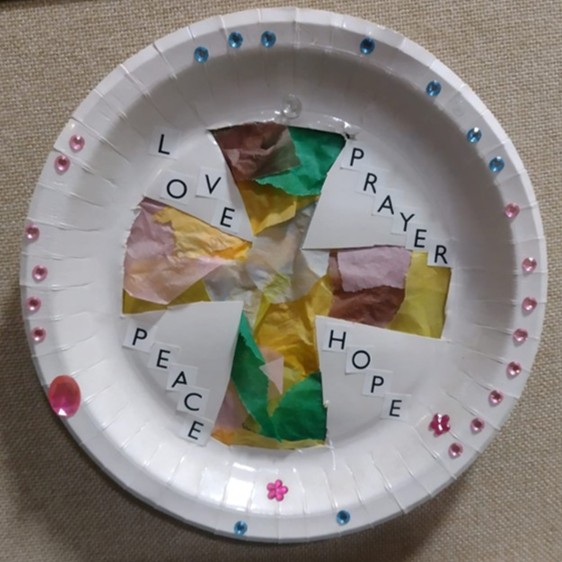 A paper plate decorated with the words love, prayer, peace and hope.