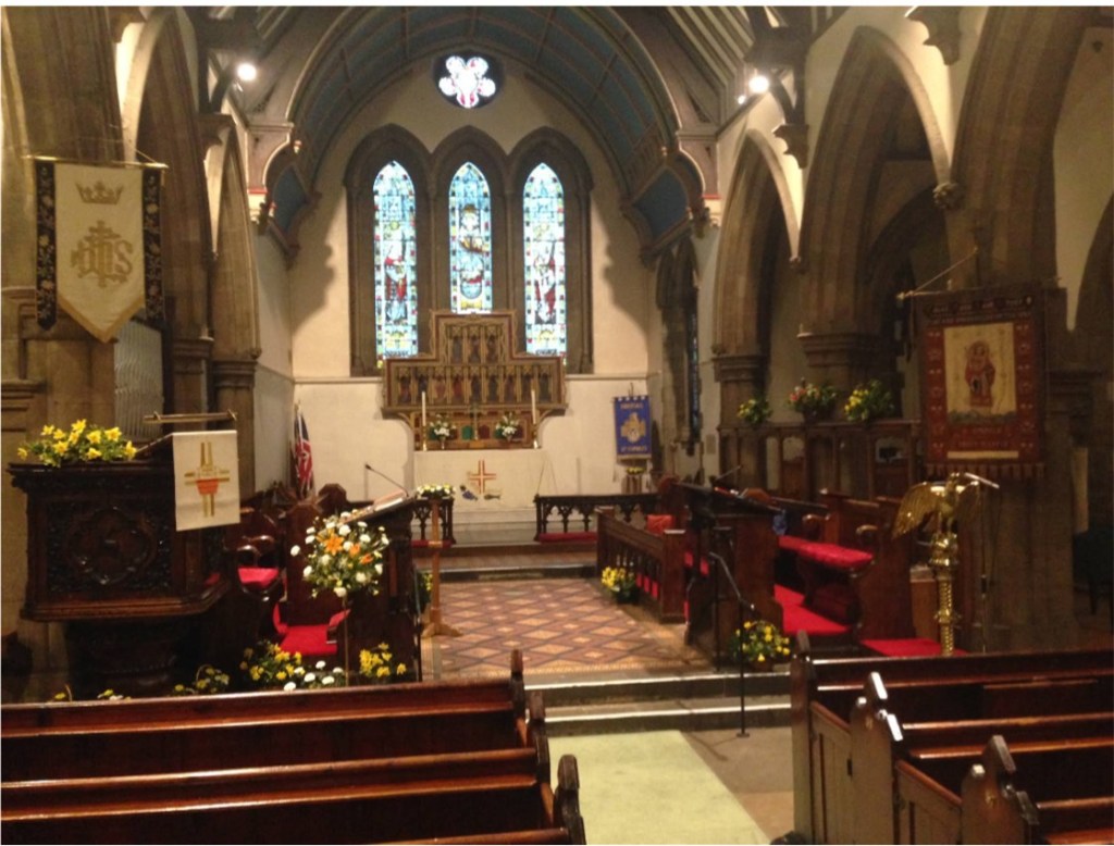 A view of the inside of St Stephen's church, with flowers and white linen on the alter